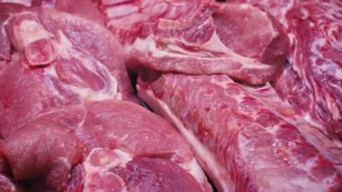 Mağazada taze çiğ et sergileniyor. Tavuk, kuzu, domuz, sığır eti alışveriş merkezinde satılır. Bir kasapta çiğ et satışı. Bir hipermarkette et bölümü. Panoramik çekim