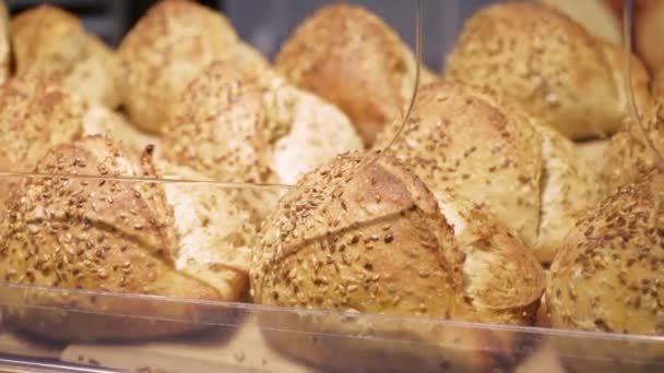 新鮮な焼きたての健康的な全パンは ゴマとリンシードでペストリーをロールバックします 食料品店で買い物 食品コンセプトの販売 — ストック動画