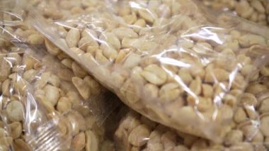 Arachis bir markette paketlenmiş plastik. Penceredeki fındıkların farklı türlerinden ambalaj. Büyük plan, atıştırmalık, sağlıklı beslenme konsepti