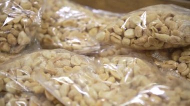 Arachis bir markette paketlenmiş plastik. Penceredeki fındıkların farklı türlerinden ambalaj. Büyük plan, atıştırmalık, sağlıklı beslenme konsepti
