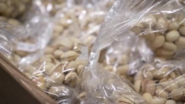 Arachis bir markette paketlenmiş plastik. Penceredeki fındıkların farklı türlerinden ambalaj. Büyük plan, atıştırmalık, sağlıklı beslenme konsepti