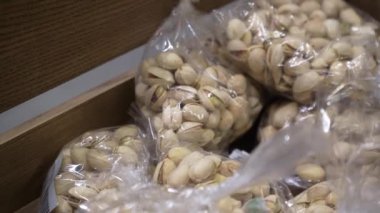 Arachis bir markette paketlenmiş plastik. Penceredeki fındıkların farklı türlerinden ambalaj. Büyük plan, atıştırmalık, sağlıklı beslenme konsepti