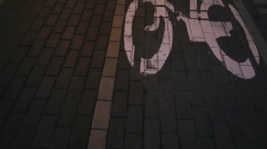 Gece bisikleti yolu. Bisiklet yolu yakındaki ışıklarla yanıyor. Bisiklet yolu