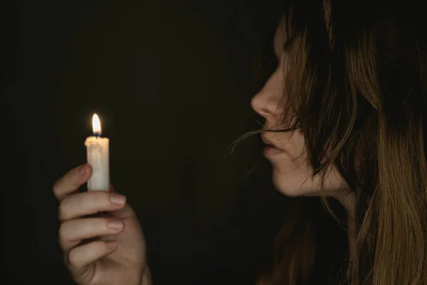 照片上的蜡烛在晚上被一个年轻的女孩抱着 把注意力集中在蜡烛上黑暗的背景可怕的恐怖概念 — 图库照片