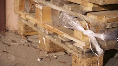 Palet rafı deposu, lojistik merkezi. Kocaman, büyük, modern bir depo. Boş ahşap paletler bir depoya istiflenmiş. Mağazada yığılmış bir sürü boş palet var.