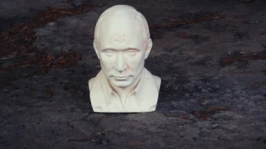 Putin kafası şeklinde alçıtaşı heykeli. Rusya Devlet Başkanı figürü bir zorbalık kavramı olarak. Putin kafası şeklindeki figürün yavaş çekim videosu.