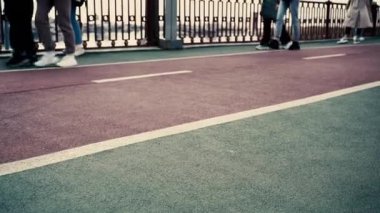 İnsanların yürüdüğü kırmızı bir bisiklet yolu. Bisiklet sürmek için bisiklet yolu. Pistte yürüyen ayaklar, yakın plan. arkaplan videosu