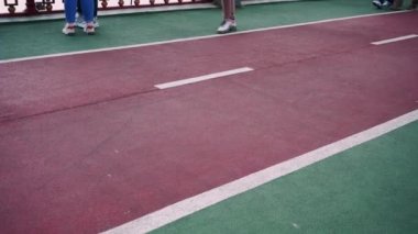 İnsanların yürüdüğü kırmızı bir bisiklet yolu. Bisiklet sürmek için bisiklet yolu. Pistte yürüyen ayaklar, yakın plan. arkaplan videosu