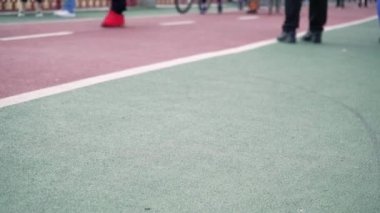 İnsanların yürüdüğü kırmızı bir bisiklet yolu. Bisiklet sürmek için bisiklet yolu. Pistte yürüyen ayaklar, yakın plan. arkaplan videosu