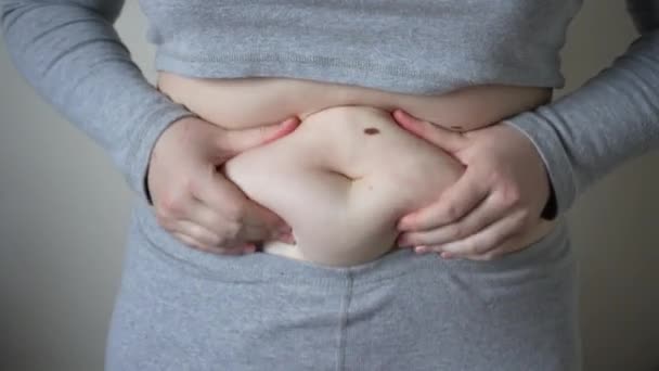 太りすぎの女性の大きな腹に脂肪の折り目のクローズアップ 太りすぎ 女性の肥満 食事や太りすぎの問題の概念 — ストック動画