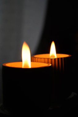 Karanlıkta yanıp sönen beyaz mumlar seti. Ön planda bir mum var. Mum yakıyorum. Yanan bir mum. Güzel el yapımı mumlar. Evin rahat atmosferi.