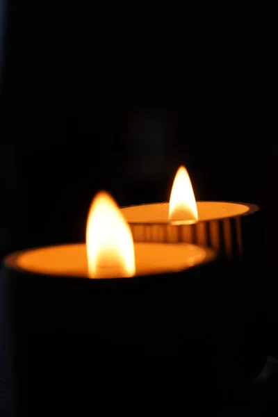 Μια Σειρά Από Αναμμένα Λευκά Κεριά Τρεμοπαίζουν Στο Σκοτάδι Μαύρο — Φωτογραφία Αρχείου