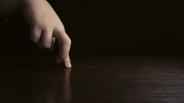 Koyu bir arka planda dans eden kadın parmakları. Eğlence ve tiyatro konsepti