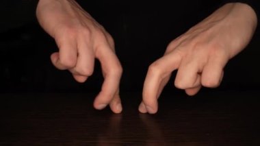 Siyah arka planda dans eden erkek parmakları. Eğlence ve tiyatro konsepti