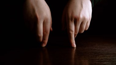 Siyah arka planda dans eden erkek parmakları. Eğlence ve tiyatro konsepti