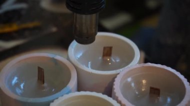 Bitmiş mumları yüzeyi düzleştirmek için saç kurutma makinesiyle işleme sokma işlemi. Mum üretimi için bir fabrika. El yapımı.