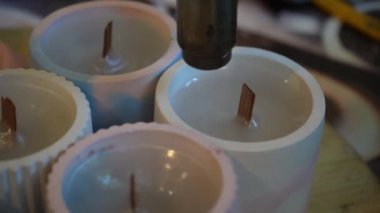 Bitmiş mumları yüzeyi düzleştirmek için saç kurutma makinesiyle işleme sokma işlemi. Mum üretimi için bir fabrika. El yapımı.