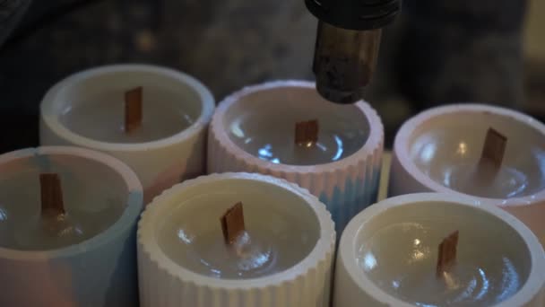 用吹风机加工完成的蜡烛以平整表面的过程 生产蜡烛的工厂 手工制作 — 图库视频影像
