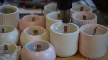 Bitmiş mumları yüzeyi düzleştirmek için saç kurutma makinesiyle işleme sokma işlemi. Mum üretimi için bir fabrika. El yapımı.