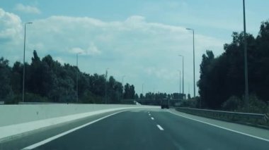 Seyahat konsepti. Hızlı giden bir arabadan manzara. Bir yaz ya da bahar günü araba penceresinden yol kenarına ve tarlalara bakın. Tasarım için arka plan dokusu. Otobandan geçen bir arabanın görüntüsü