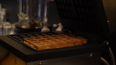 Bir kafede waffle makinesinde Belçika Waffle 'ı pişirmek. Profesyonel bir mutfakta waffle makinesine waffle hamuru döken bir şefin yakın çekimi.