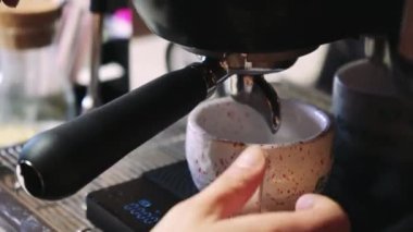 Video kahve makineden fincana akar. Ev yapımı sıcak espresso. Taze öğütülmüş kahve akar. Bir barista kafede kahve hazırlar.