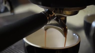 Video kahve makineden fincana akar. Ev yapımı sıcak espresso. Taze öğütülmüş kahve akar. Bir barista kafede kahve hazırlar.