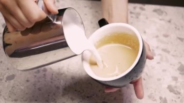 Kahveci sütü buharda pişirir. Süt köpüğü üretme süreci. Latte işlem yapıyor. Kahve makinesinden çıkan sıcak buharla süte çırpılmış kahve içen barista.