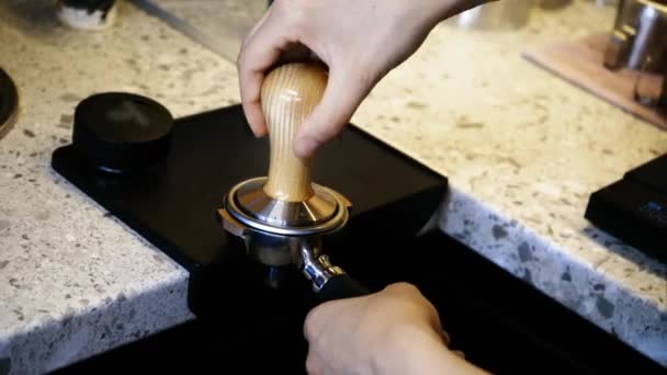 新鮮なコーヒーを改造した地上のコーヒーの準備 新鮮な地上のコーヒーのタンパー バリスタの手は コーヒーのカップを作る準備ができてポータルフィルターに地面コーヒー粉を保持し 押します — ストック動画