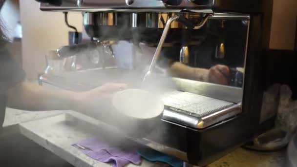 コーヒーメーカーのスチームチューブを吹く コーヒーマシンからの蒸気との皿の消毒 バー内の清潔さと衛生の維持 バリスタの職場を掃除する — ストック動画