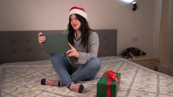Kerstgroeten Online Een Vrouw Een Grijze Trui Een Rode Kerstmuts — Stockvideo