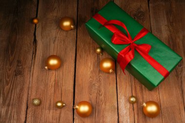 Kutlama hediye kutusu ve ahşap arka planda altın Noel ağacı süslemeleri. Tatil konsepti. Noel, Yeni Yıl, Doğum günü, Kadın Tatili