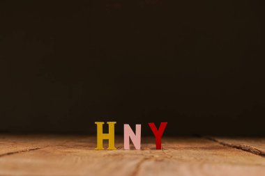 Mutlu yeni yıl mektupları, tahtadan arka planda konfeti olan hediye kutusu. Neşeli bir atmosfer. Yeni yıl kavramı