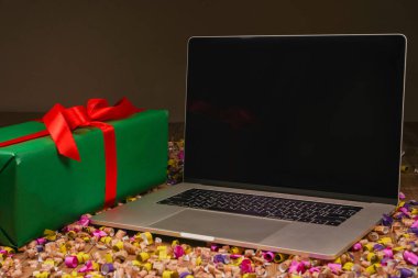 Dizüstü bilgisayarlı Noel işyeri. Ahşap arka planda konfeti ve süs eşyası. Üst görünüm, boşluğu kopyala. Kobota Noel gecesi