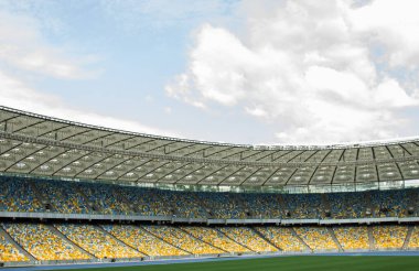 futbol stadyumu içinde görünümü. futbol sahası, boş tribünler, taraftar kalabalığı, gökyüzüne karşı bir çatı.