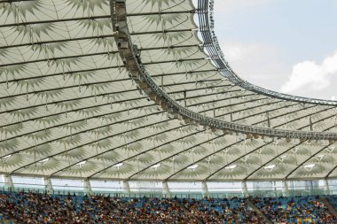 futbol stadyumu içinde görünümü. futbol sahası, boş tribünler, taraftar kalabalığı, gökyüzüne karşı bir çatı.