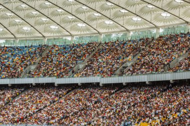 futbol stadyumu içinde görünümü. futbol sahası, boş tribünler, taraftar kalabalığı, gökyüzüne karşı bir çatı.