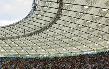 futbol stadyumu içinde görünümü. futbol sahası, boş tribünler, taraftar kalabalığı, gökyüzüne karşı bir çatı.