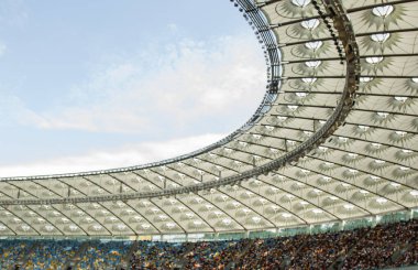 futbol stadyumu içinde görünümü. futbol sahası, boş tribünler, taraftar kalabalığı, gökyüzüne karşı bir çatı.