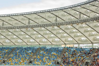 futbol stadyumu içinde görünümü. futbol sahası, boş tribünler, taraftar kalabalığı, gökyüzüne karşı bir çatı.