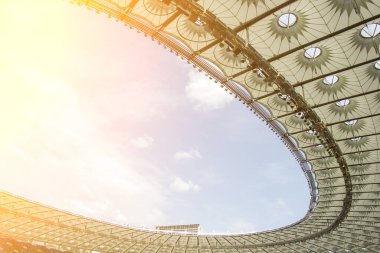futbol stadyumu içinde görünümü. futbol sahası, boş tribünler, taraftar kalabalığı, gökyüzüne karşı bir çatı.