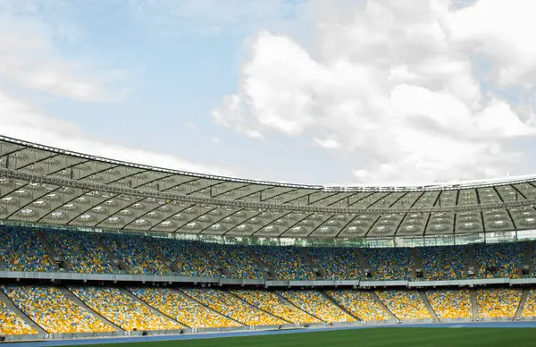 futbol stadyumu içinde görünümü. futbol sahası, boş tribünler, taraftar kalabalığı, gökyüzüne karşı bir çatı.