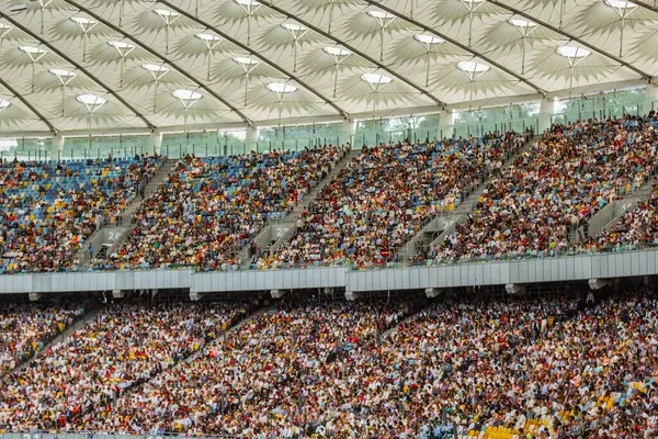soccer stadium inside view. football field, empty stands, a crowd of fans, a roof against the sky.