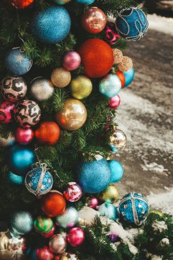 Yeni yıl ağacı dallarında kırmızı, beyaz, mavi ve yeşil süslemeler. Noel ağacı süsü, kış tatili için dekor. Kışın ev dekorasyonu. Şenlik havası. Yeni yıl kartı. Noel arkaplanı