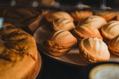 Yanında turta ve konsantre süt olan fındık tatlısı. Bir fırın ya da kahve dükkanı vitrini. Bir vitrindeki çeşitli mini tatlılar. Modern fırın ya da pastane
