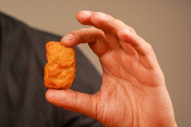 Tavuk nugget yiyen adam. Sağlıksız bir yaşam tarzı. Kaloriler, obezite, Amerikan yemekleri. Fast and abur cubur. Ketçaplı tavuk nugget. Tavuklu nugget tutuyorum.