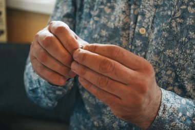 Usta atölyede mum yapıyor. Adam elleriyle bir şey üzerinde çalışıyor.