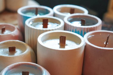 Soya mumları geri dönüşümlü şişe ve kavanozlara döküldü. Mağaza veya atölye arka planında birçok soya mumları birlikte. Ekolojik ve vejetaryen işleri