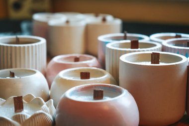 Ekolojik ve vejetaryen işleri. Soya mumları geri dönüşümlü şişe ve kavanozlara döküldü. Mağaza veya atölye arka planında birçok soya mumu bir arada