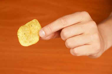 Obezite. Amerikan yemeği. Sağlıksız bir yaşam tarzı. Patates cipsi yiyen adam. Fast food. Abur cubur. Patates cipsini yakın plan çekiyoruz. Kaloriler